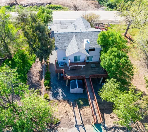a view of house with roof deck and potted plants