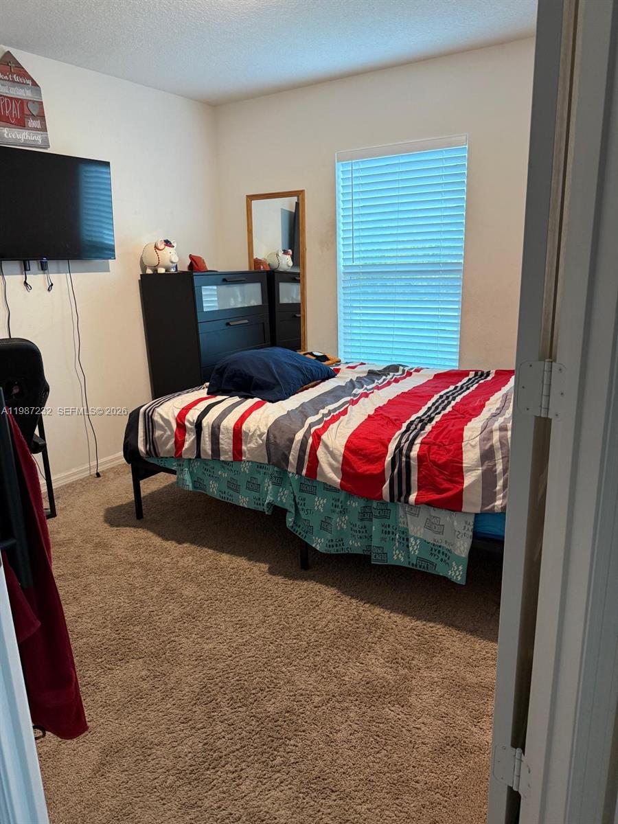 3902 Southwest Brunswick Street Port St. Lucie, FL 34953 - Photo 3 of 23 a bedroom with a bed and flat screen tv