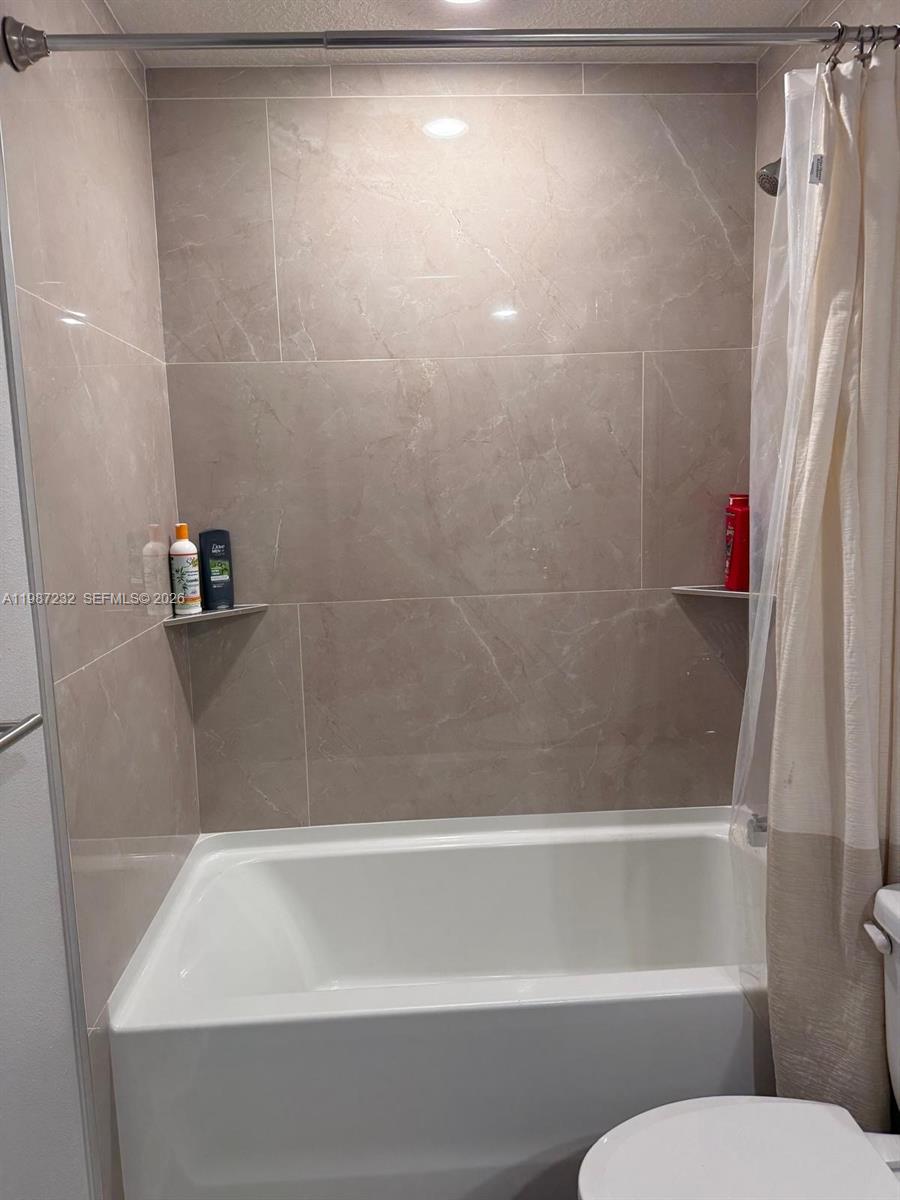 3902 Southwest Brunswick Street Port St. Lucie, FL 34953 - Photo 5 of 23 a bathroom with a bathtub and a shower