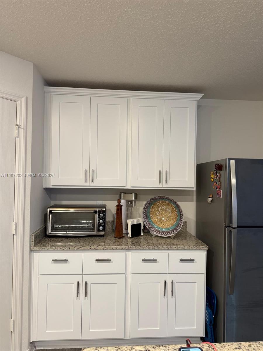 3902 Southwest Brunswick Street Port St. Lucie, FL 34953 - Photo 10 of 23 a kitchen with white cabinets and refrigerator