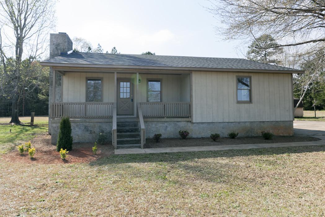132 Reid Place Road Thomaston, GA 30286 - Photo 1 of 1 a view of a stone house with a small yard and large tree