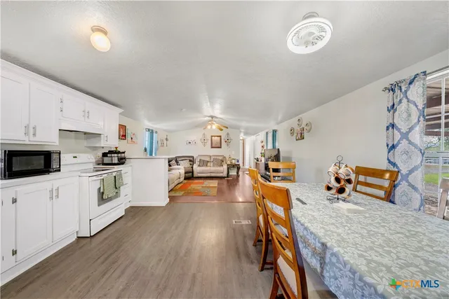 a kitchen with stainless steel appliances wooden floor and a refrigerator