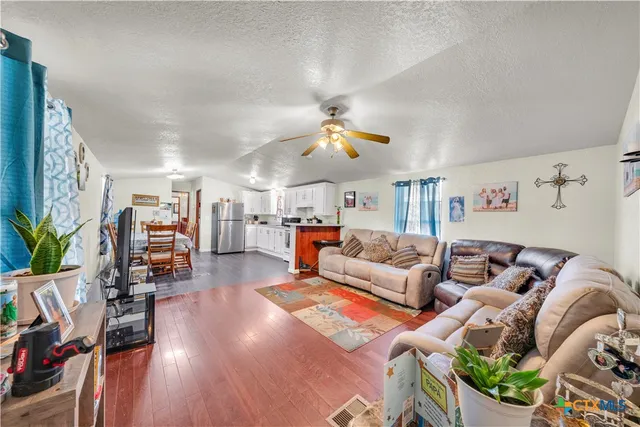 a living room with furniture kitchen view and a large window
