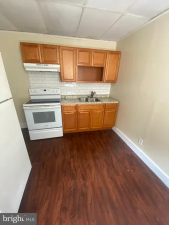 a kitchen with wooden floors and granite counter tops