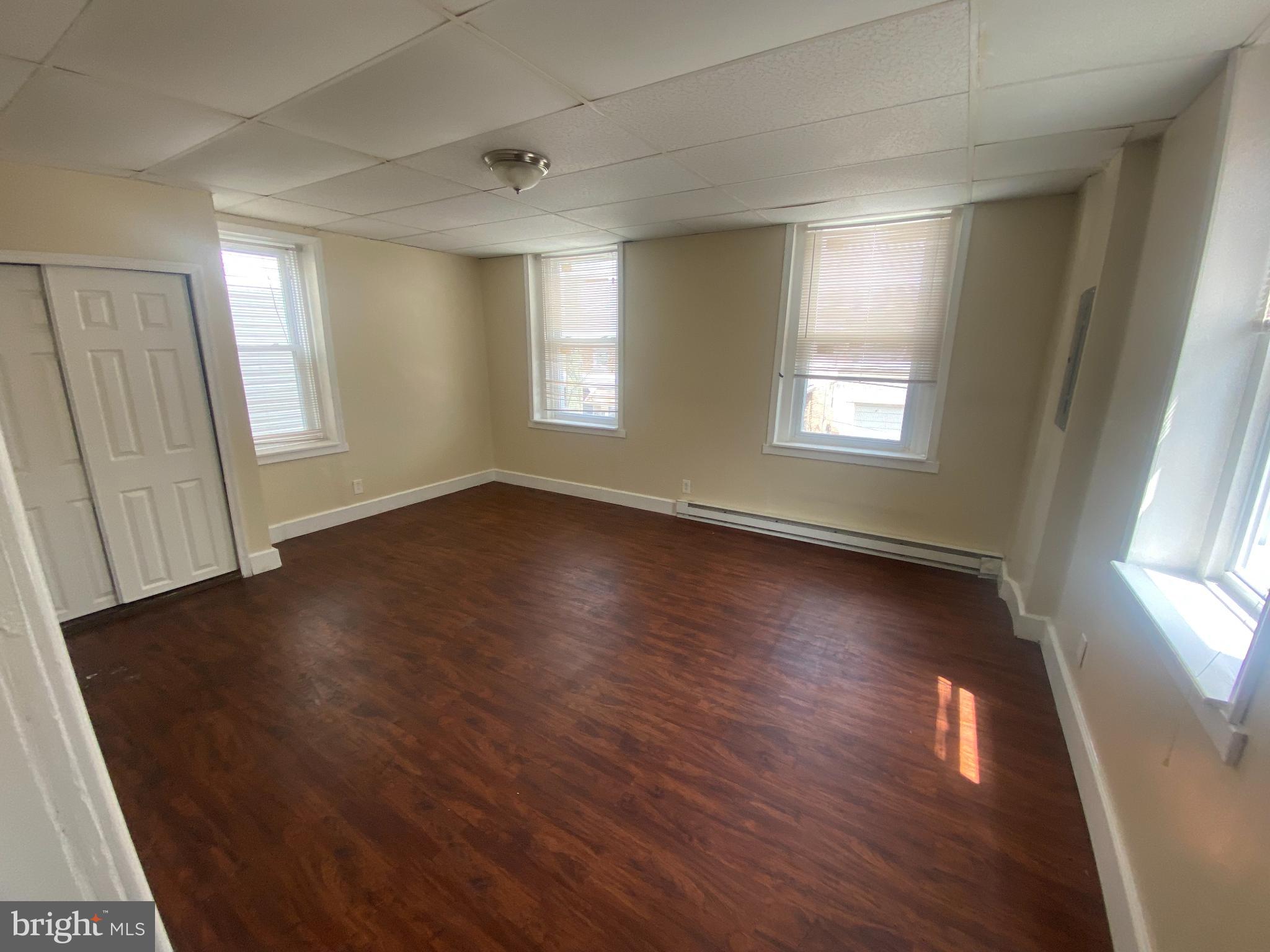 432 North 64th Street, Unit 2F Philadelphia, PA 19151 - Photo 6 of 7 an empty room with wooden floor and windows