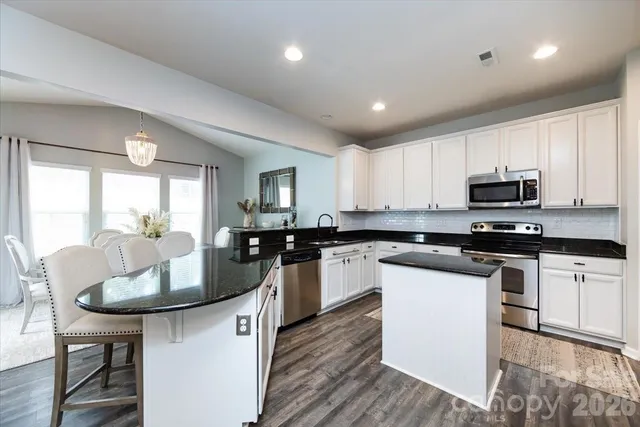 a kitchen with sink a microwave and cabinets