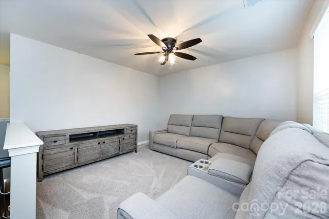 a living room with furniture and a ceiling fan