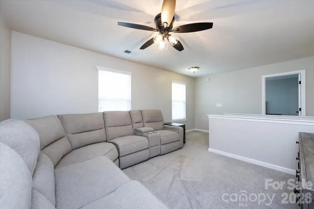 a living room with furniture and a ceiling fan