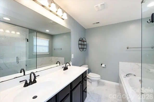 a bathroom with a sink double vanity and a toilet