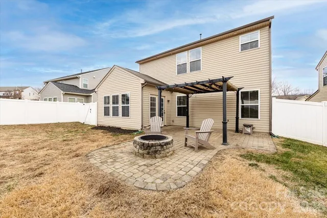 a big white house with a white roof and wooden fence