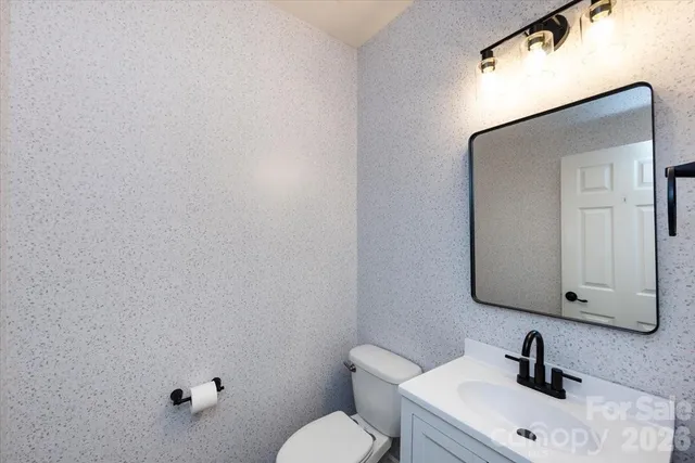 a bathroom with a sink mirror and toilet