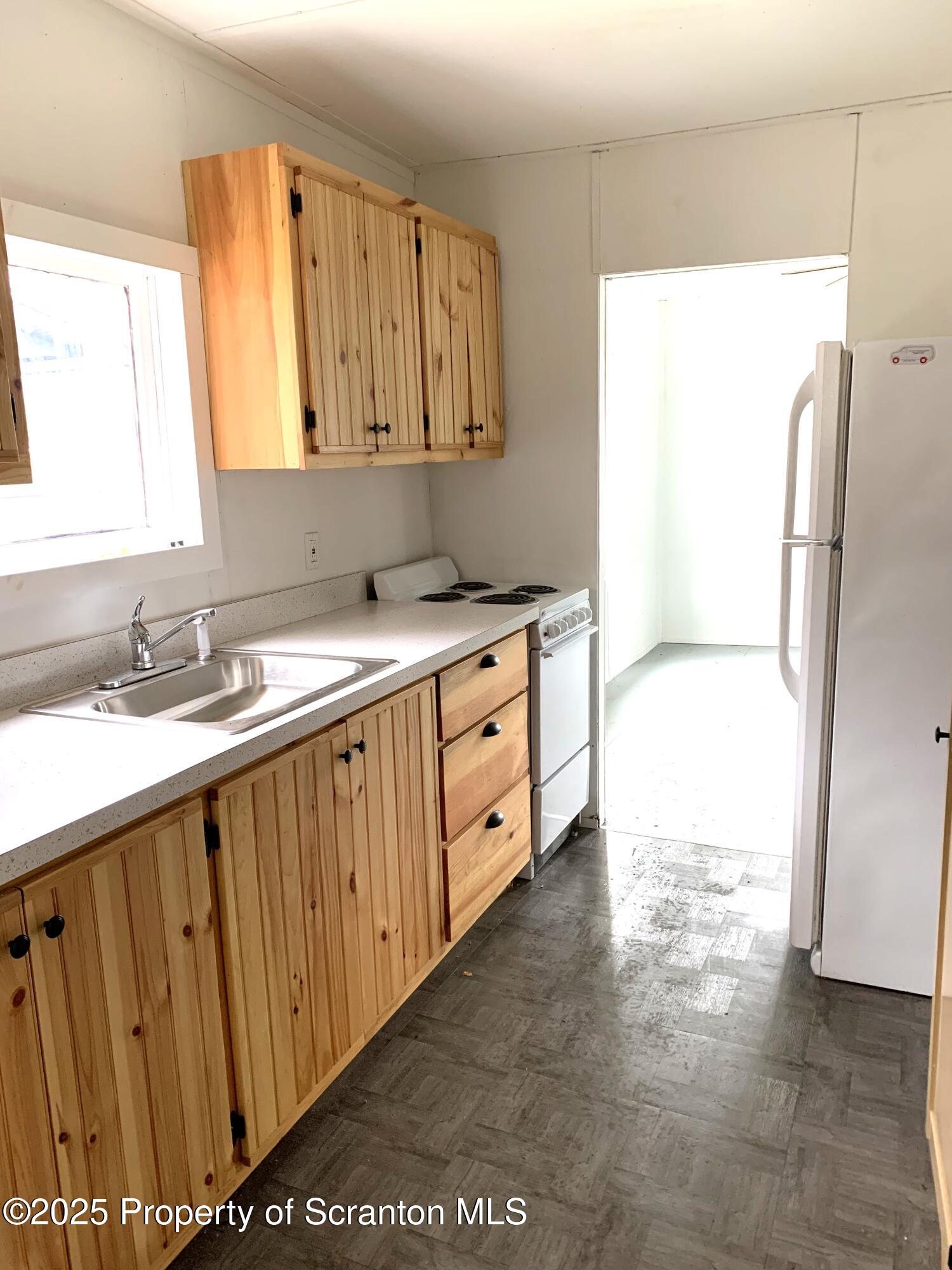 335 South Shore Drive Thompson, PA 18465 - Photo 7 of 15 a kitchen with stainless steel appliances a sink cabinets and a window