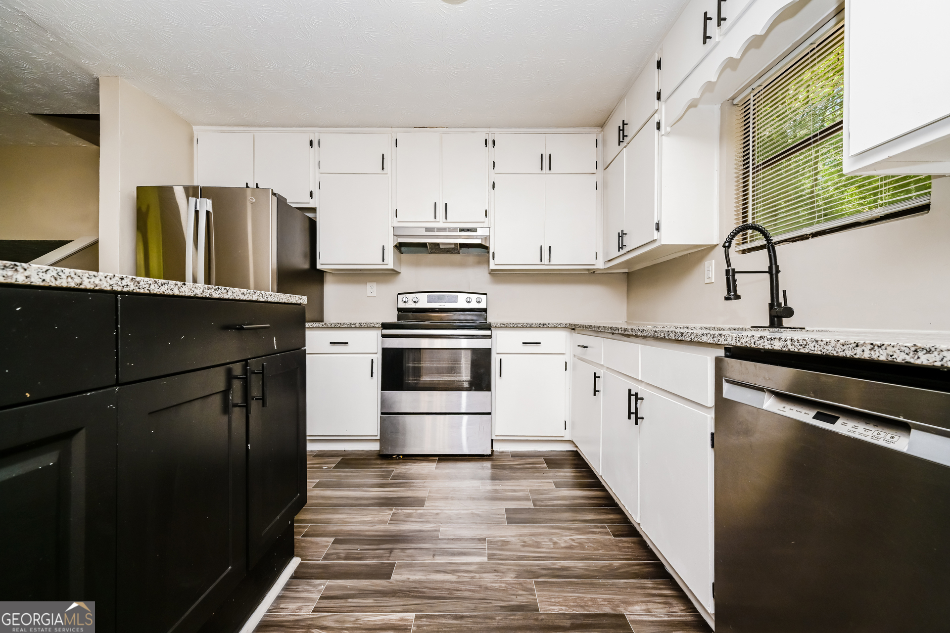 4301 Dogwood Farms Drive Decatur, GA 30034 - Photo 8 of 22 a kitchen with granite countertop a refrigerator a sink and white cabinets