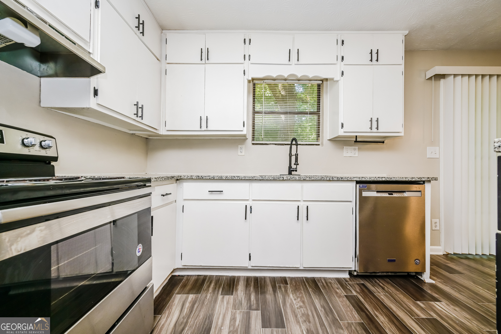 4301 Dogwood Farms Drive Decatur, GA 30034 - Photo 9 of 22 a kitchen with granite countertop white cabinets and white appliances