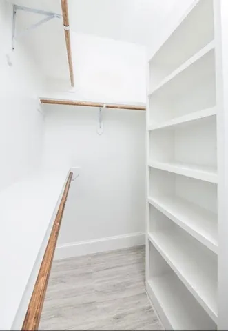 a view of walk in closet with empty racks