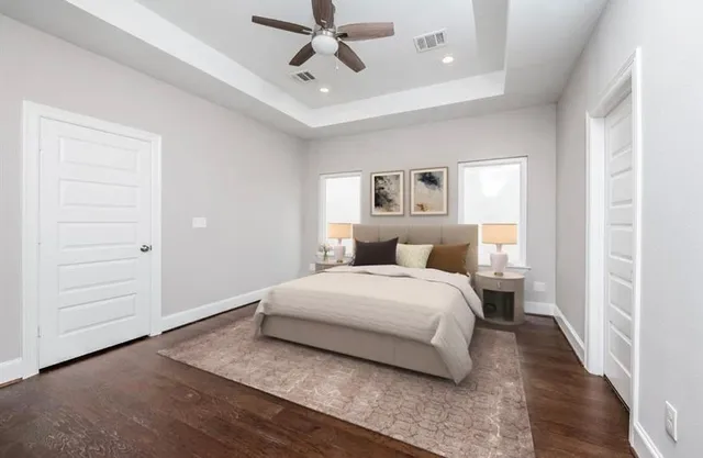 a spacious bedroom with a bed and a chandelier