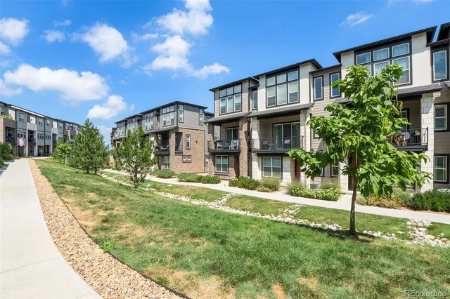 a view of a brick house with large windows and a tree