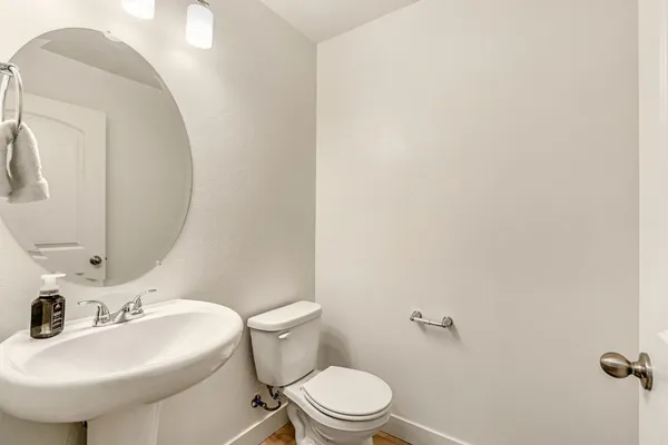 a bathroom with a sink a toilet and mirror