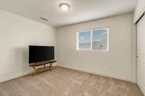 a living room with workspace and a flat screen tv