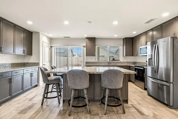 a kitchen with refrigerator cabinets dining table and chairs