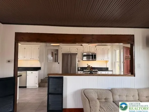 a living room with furniture a flat screen tv and a wooden floor