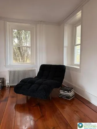 a view of a hallway with wooden floor and windows