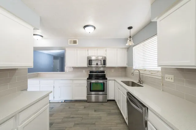 a large white kitchen with a large window