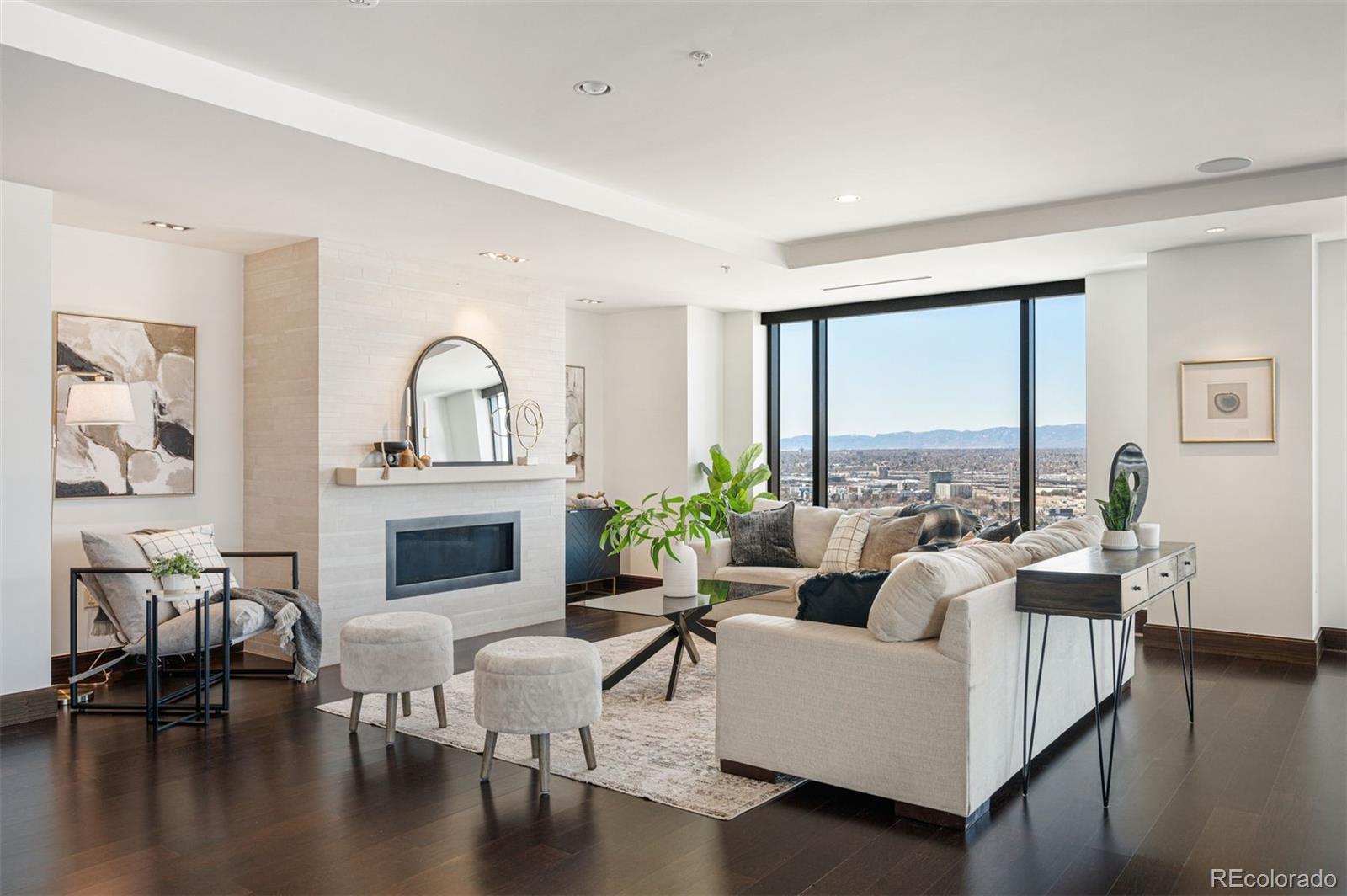 a living room with furniture a fireplace and a large window