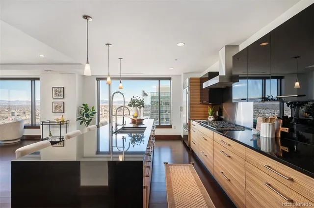 a large kitchen with granite countertop a large counter top appliances and cabinets