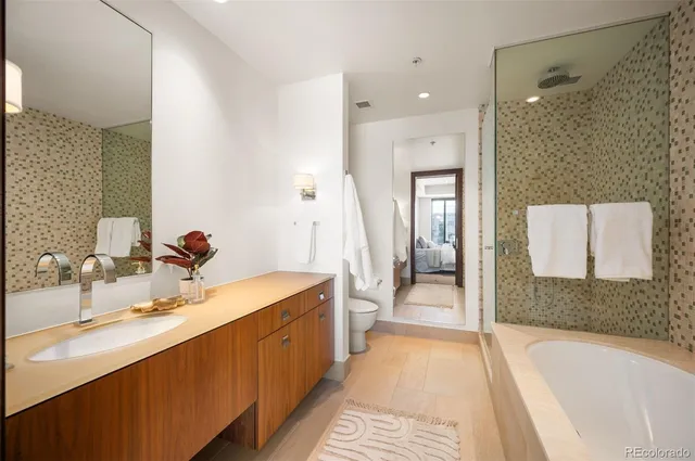 a bathroom with a tub sink and mirror