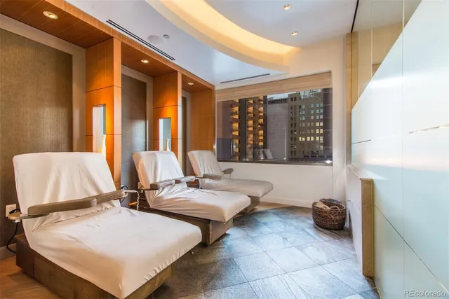 a large living room with a large window and a chandelier