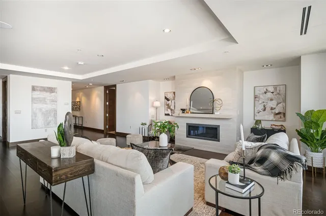 a living room with furniture a fireplace and a potted plant