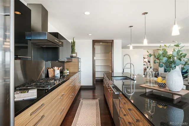 a kitchen with stainless steel appliances granite countertop a stove a sink and a wooden floors