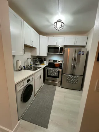 a kitchen with stainless steel appliances granite countertop a refrigerator a stove a sink and a microwave