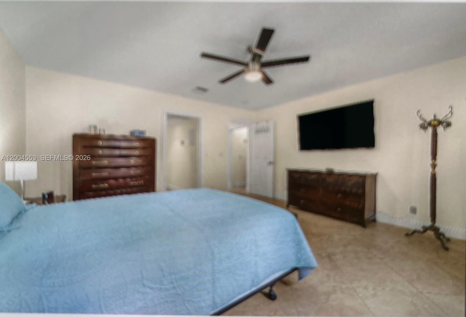13990 Nesting Way, Unit C Delray Beach, FL 33484 - Photo 14 of 18 a bedroom with a bed and a flat screen tv