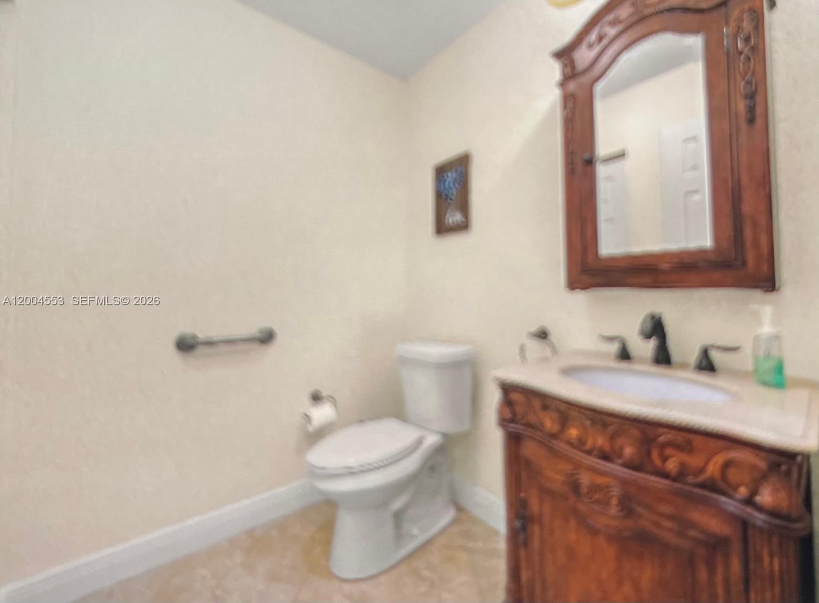 13990 Nesting Way, Unit C Delray Beach, FL 33484 - Photo 17 of 18 a bathroom with a granite countertop toilet sink and mirror