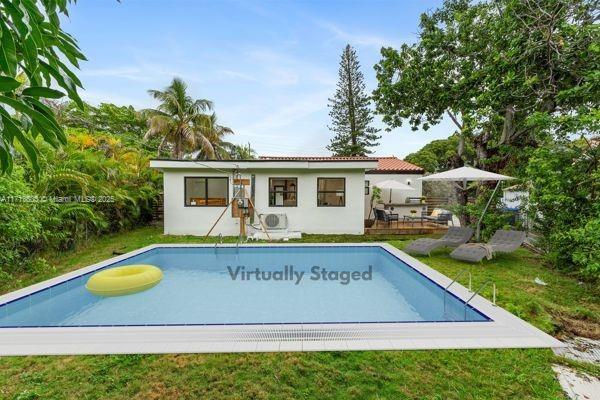 1024 Southwest 23rd Road Miami, FL 33129 - Photo 31 of 33 a view of swimming pool with seating area and trees in the background