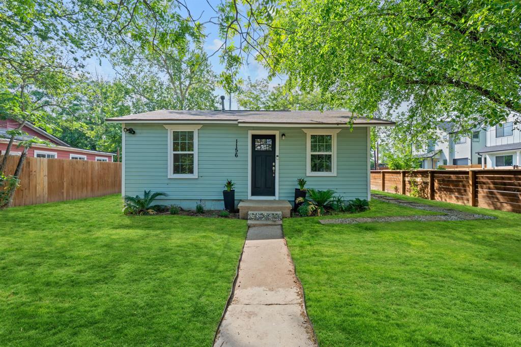 a view of a yard in front of a house with large tree