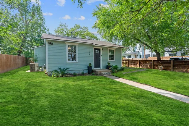 a view of a yard in front of a house with large tree