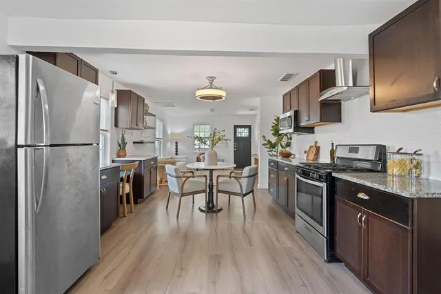 a kitchen with stainless steel appliances a sink dishwasher a stove and a microwave oven with cabinets