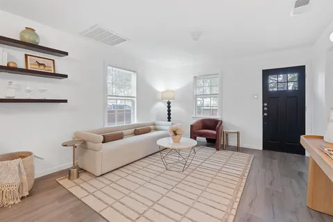 a kitchen with stainless steel appliances granite countertop a refrigerator a stove top oven a sink dishwasher and white cabinets with wooden floor