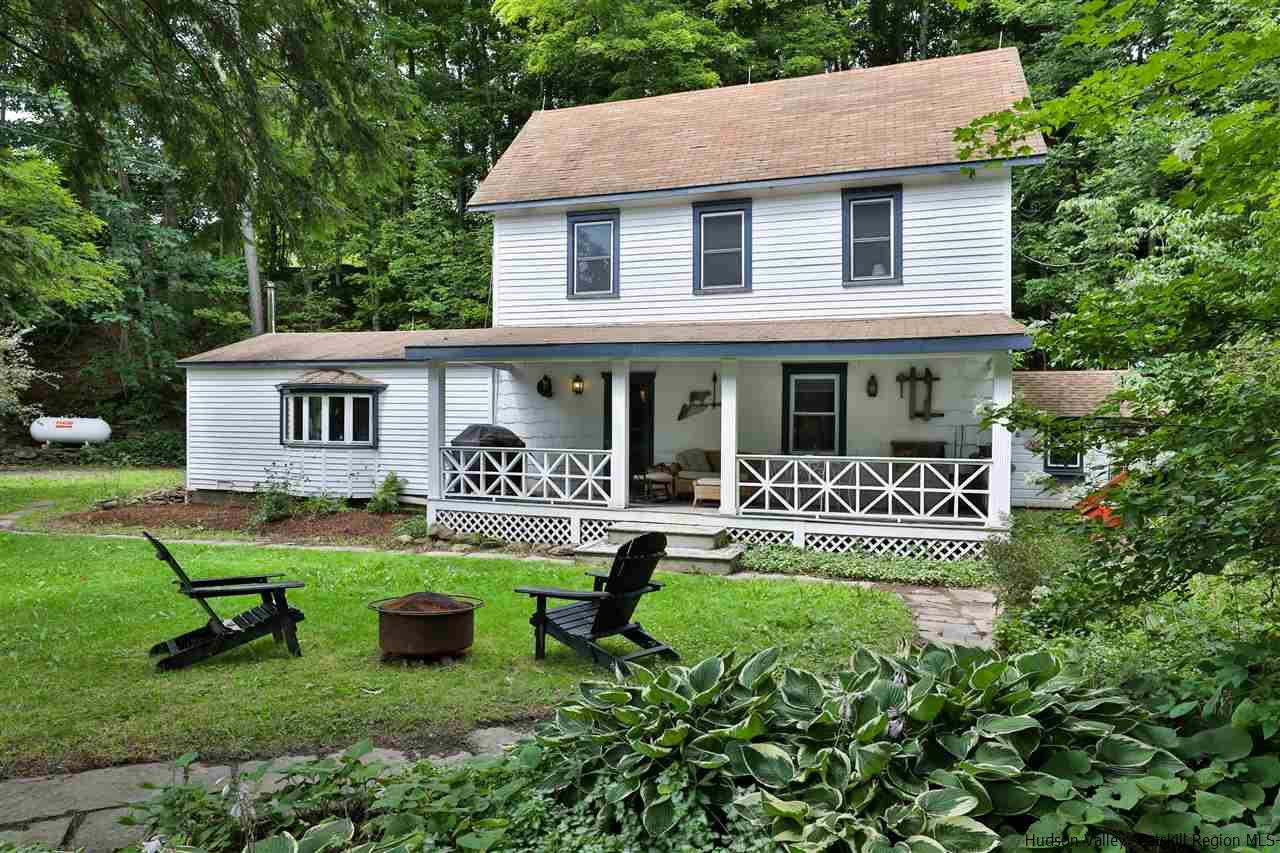 a front view of a house with a yard patio and outdoor seating