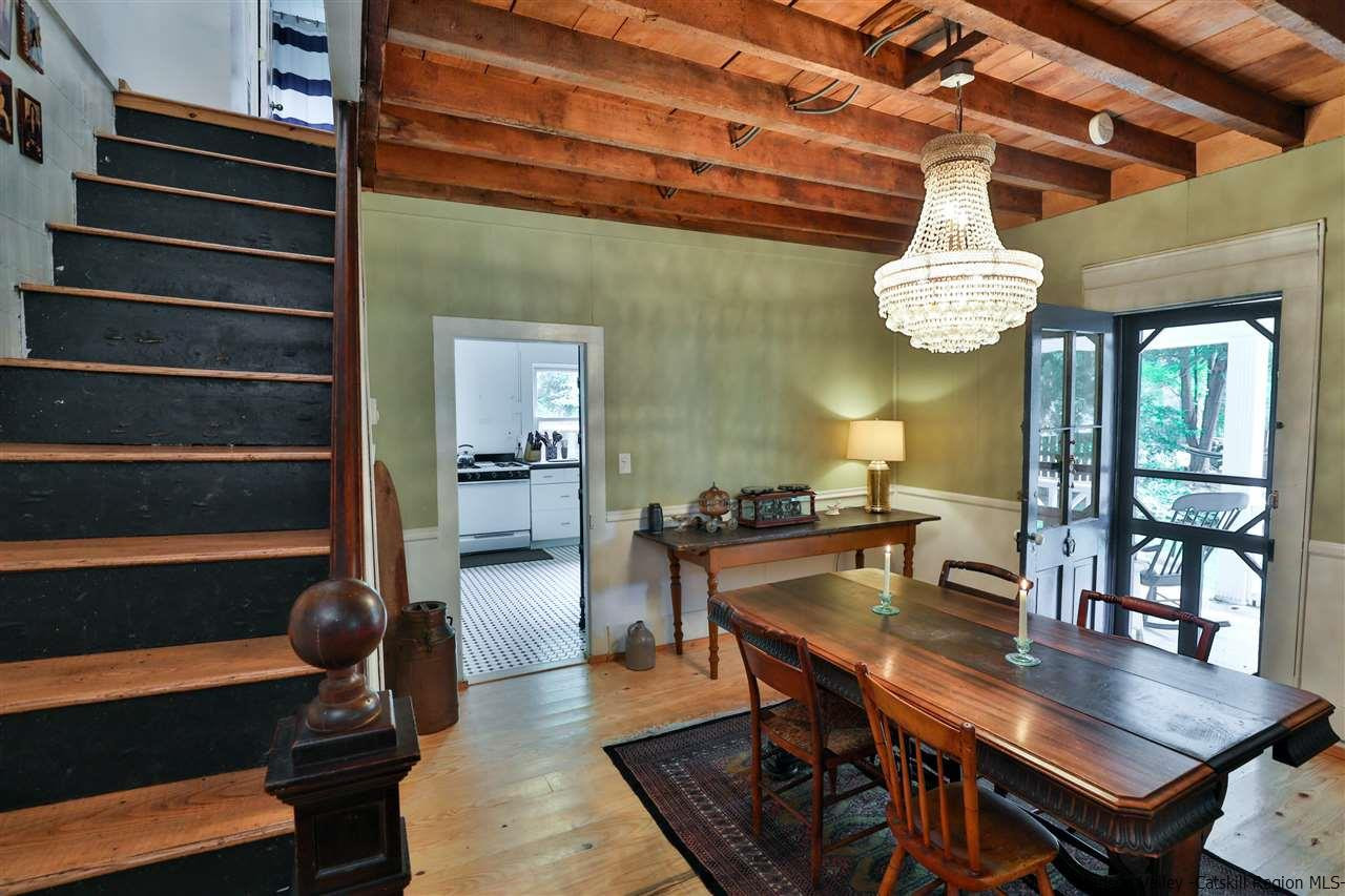 499 County Route 3 Fleischmanns, NY 12430 - Photo 8 of 25 a dining room with wooden floor a chandelier a wooden table and chairs
