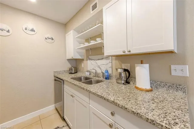 a kitchen with granite countertop a sink a stove and cabinets