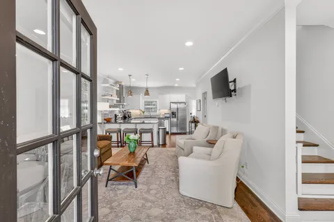 a living room with furniture kitchen view and a flat screen tv