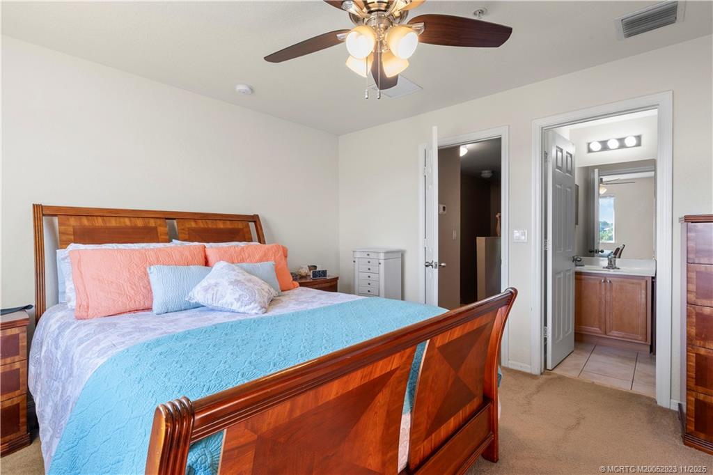 5321 Southeast Jennings Lane Stuart, FL 34997 - Photo 14 of 19 a bed sitting in a bedroom and a chandelier