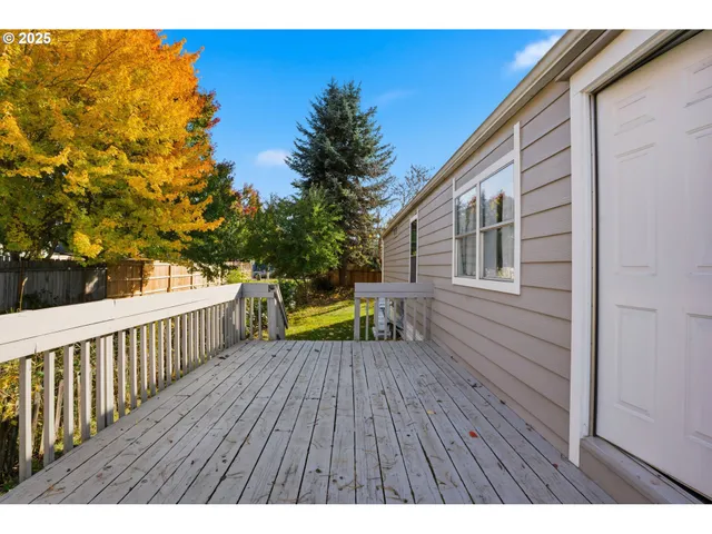 a view of deck with wooden floor and fence with a large window