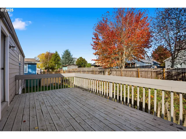 a view of backyard with potted plants and wooden fence