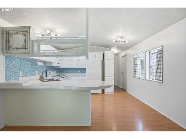 a open kitchen with kitchen island a sink a stove and wooden floors