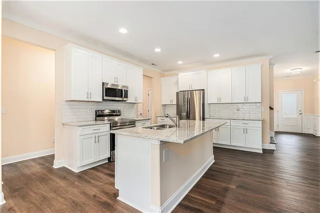 a kitchen with white cabinets and stainless steel appliances
